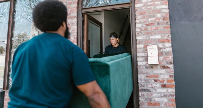 Furniture movers carrying a large couch through a tight Cape Town doorway